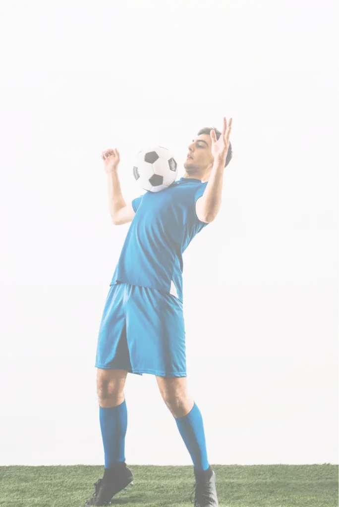Professional football player in a blue uniform controlling a soccer ball during a training session on a clean studio-style background.